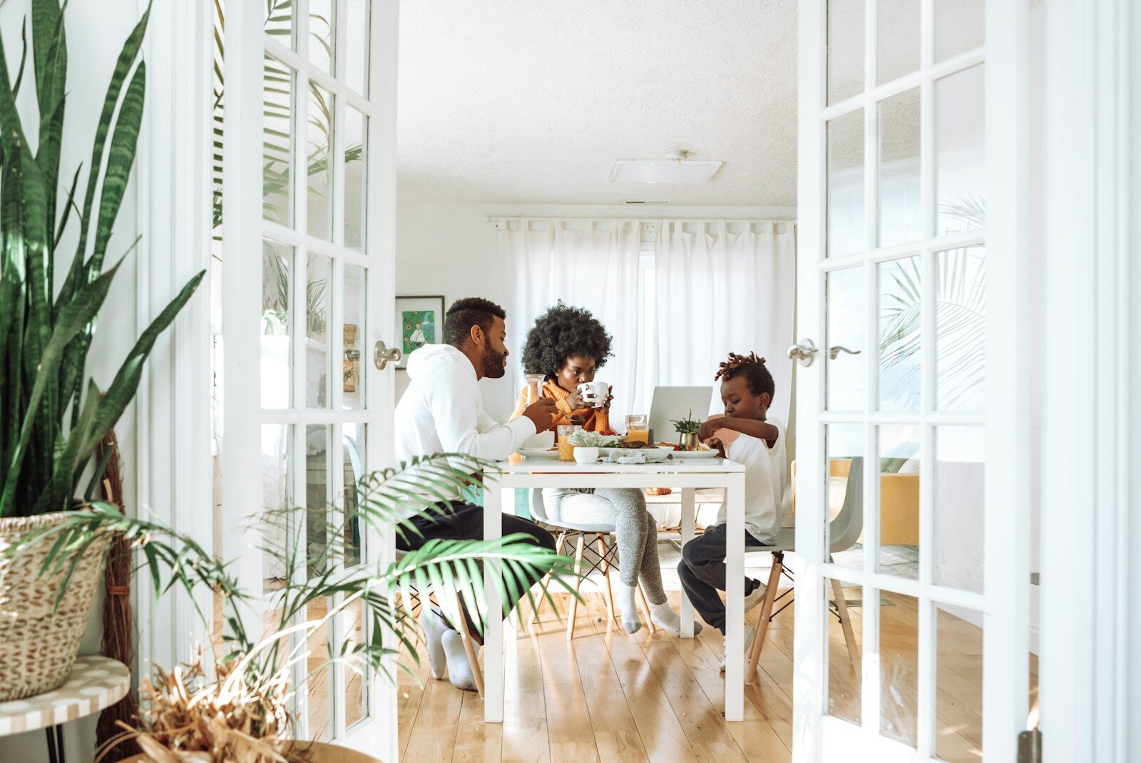 A family enjoys a meal together at a bright kitchen table, showcasing connection and togetherness in a modern, inviting space.